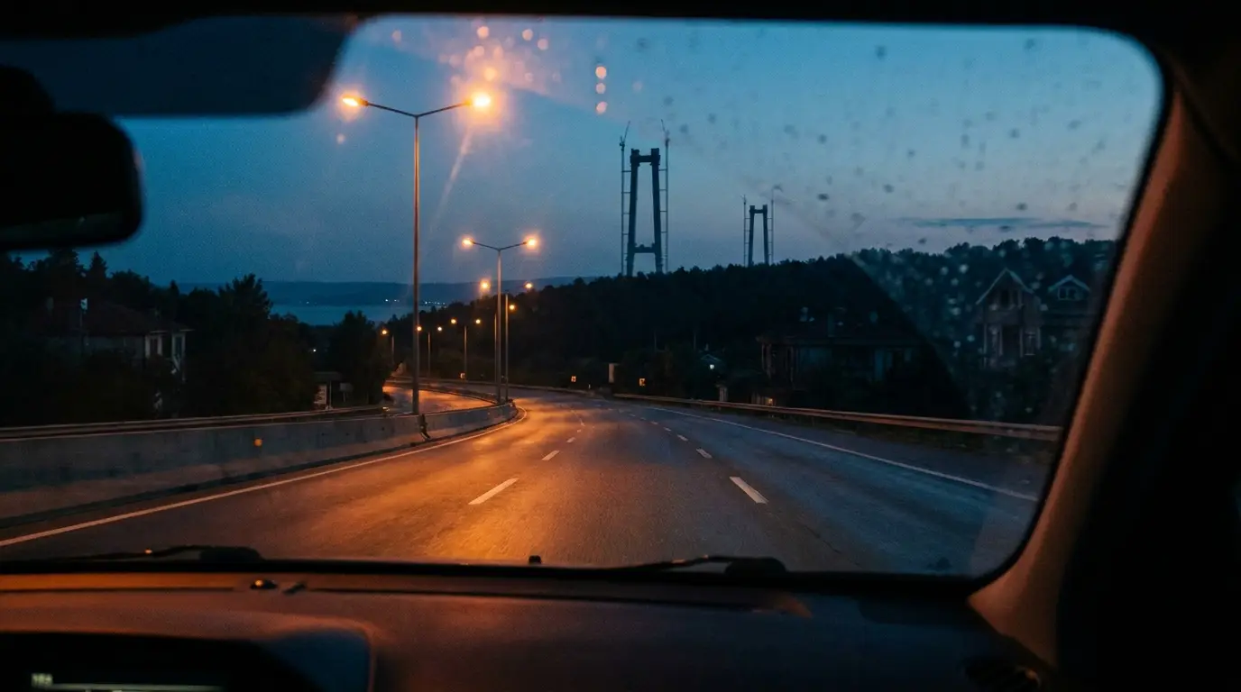 A motorway running through forest with the bridge towers appearing ahead.